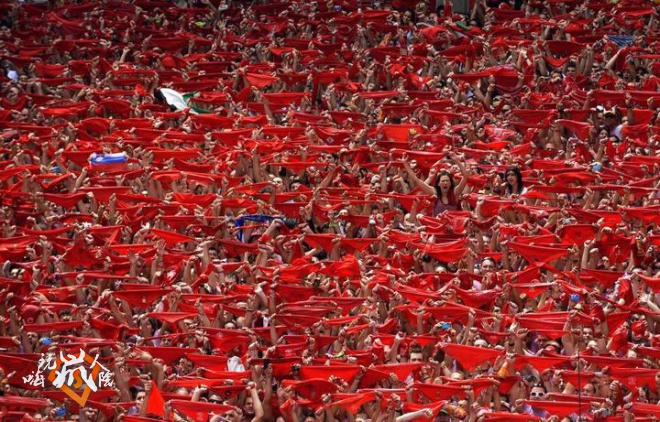 Revellers hold up red scarves during the start of the San Fermin Festival in Pamplona