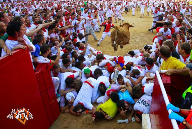 A fighting cow leaps over revellers upon entering the bullring following the first running of the bulls of the San Fermin festival in Pamplona